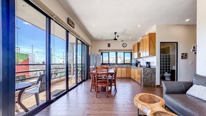 A spacious living area with a balcony, a dining set, and a kitchen area. - Ocean View 2 BR Villa with Pool (Isla Mujeres)