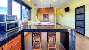 Een moderne keuken met een groot keukeneiland, een inbouwoven en barkrukken.