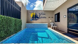 A swimming pool with a tiled design, a mural with a sailboat, and a door to the right. - Ocean View 6 BR House Steps from Ocean! (Isla Mujeres)
