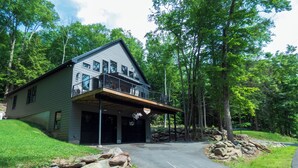A two-story house with a covered garage and a stone retaining wall.