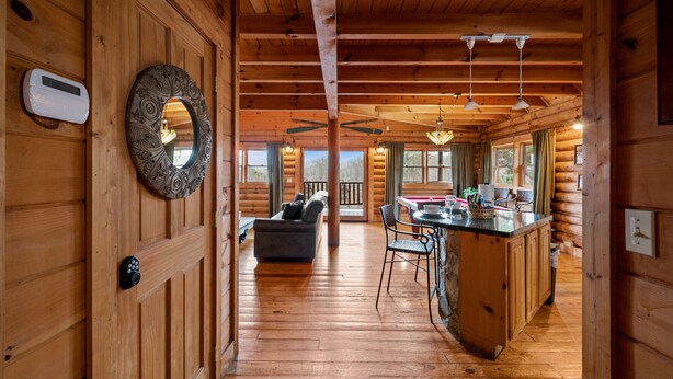 L’intérieur d’une cabane en rondins comprend un espace de vie central, une cuisine et un coin repas.