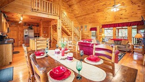 Ein Holzblockhaus-Innenraum mit Essbereich, Küche und Wohnzimmer.