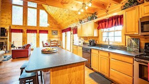 Eine geräumige Holzblockhütte mit einer großen Küche, einem Essbereich und einem gemütlichen Wohnzimmer.