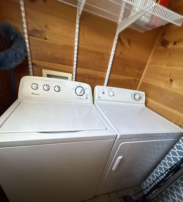 A laundry room with two white Amana washing machines.