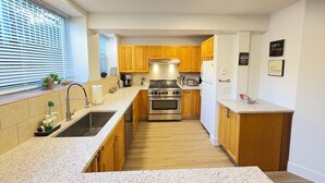 A modern kitchen with wooden cabinets, stainless steel appliances, and granite countertops. - New 2 Bedroom Suite Fairfield Heritage Manor, Free Parking (Victoria)