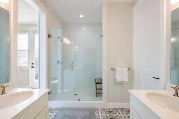 A bathroom with two sinks, a glass shower enclosure, and a patterned floor. - Private Hot Tub, Views of the Lake, just min to Main St!, Private Hot Tub, Views of the Lake, just m (Hideout)
