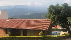 Un edificio con techo de tejas, fachada de ladrillo y camino de entrada pavimentado.