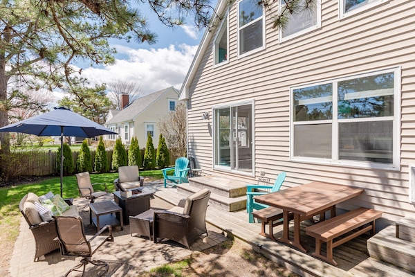 The fenced patio area features a fire pit, outdoor shower, and picnic table.