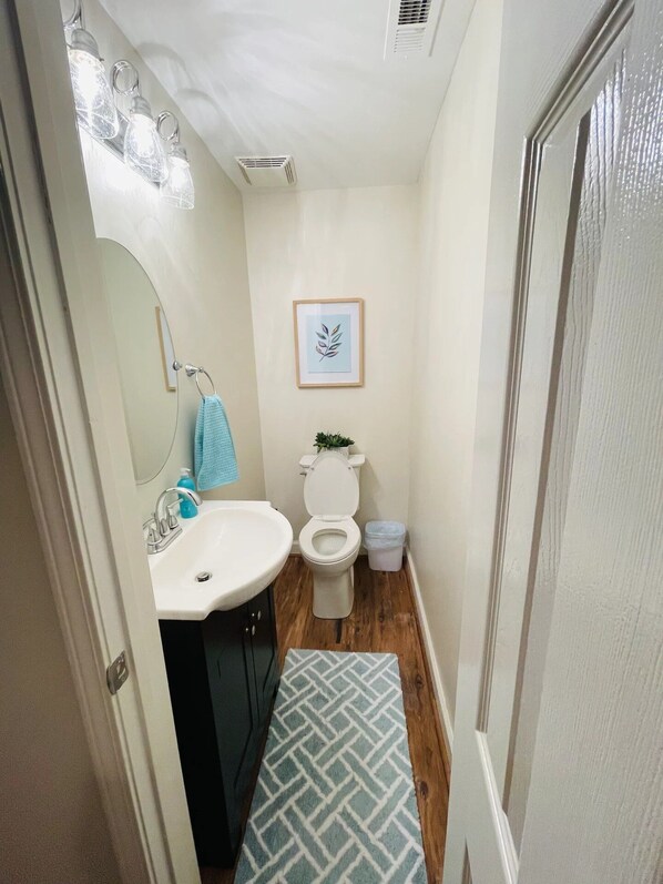 A bathroom with a sink, toilet, and mirror. - Great access to everything you will need (Georgetown)