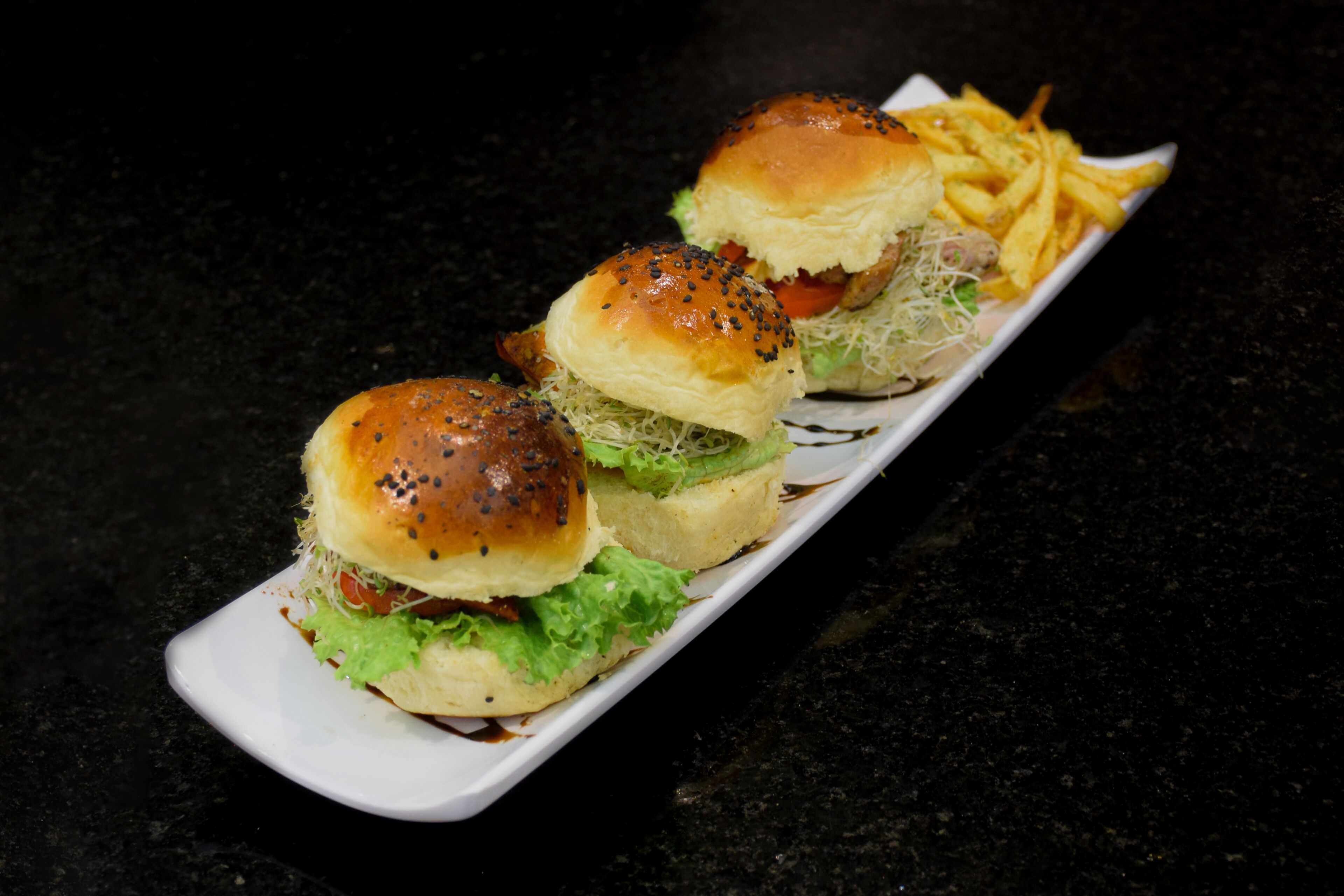 A tray with three burgers and a side of fries.