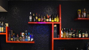 A bar area with shelves of liquor bottles. - Hotel Passion Secrets Villas & Suites (Toluca)