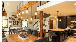 Una cocina moderna con armarios oscuros, una isla central e iluminación colgante.