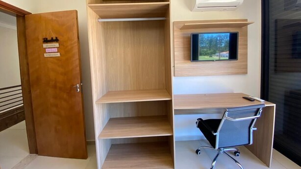 Ett modernt kontorsutrymme med inbyggda hyllor, ett skrivbord och en stol.