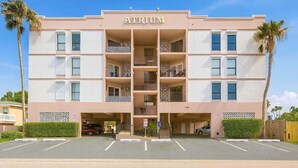 A multi-story atrium building with a central open space, balconies, and a parking area. - Walk to Beach - Heart of Entertainment District 1 Bedroom Home by RedAwning (South Padre Island)