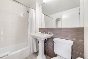 A modern bathroom with a bathtub, a sink, and a toilet.