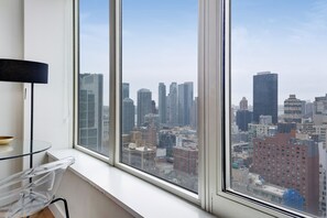 A room with a large window overlooking a cityscape.