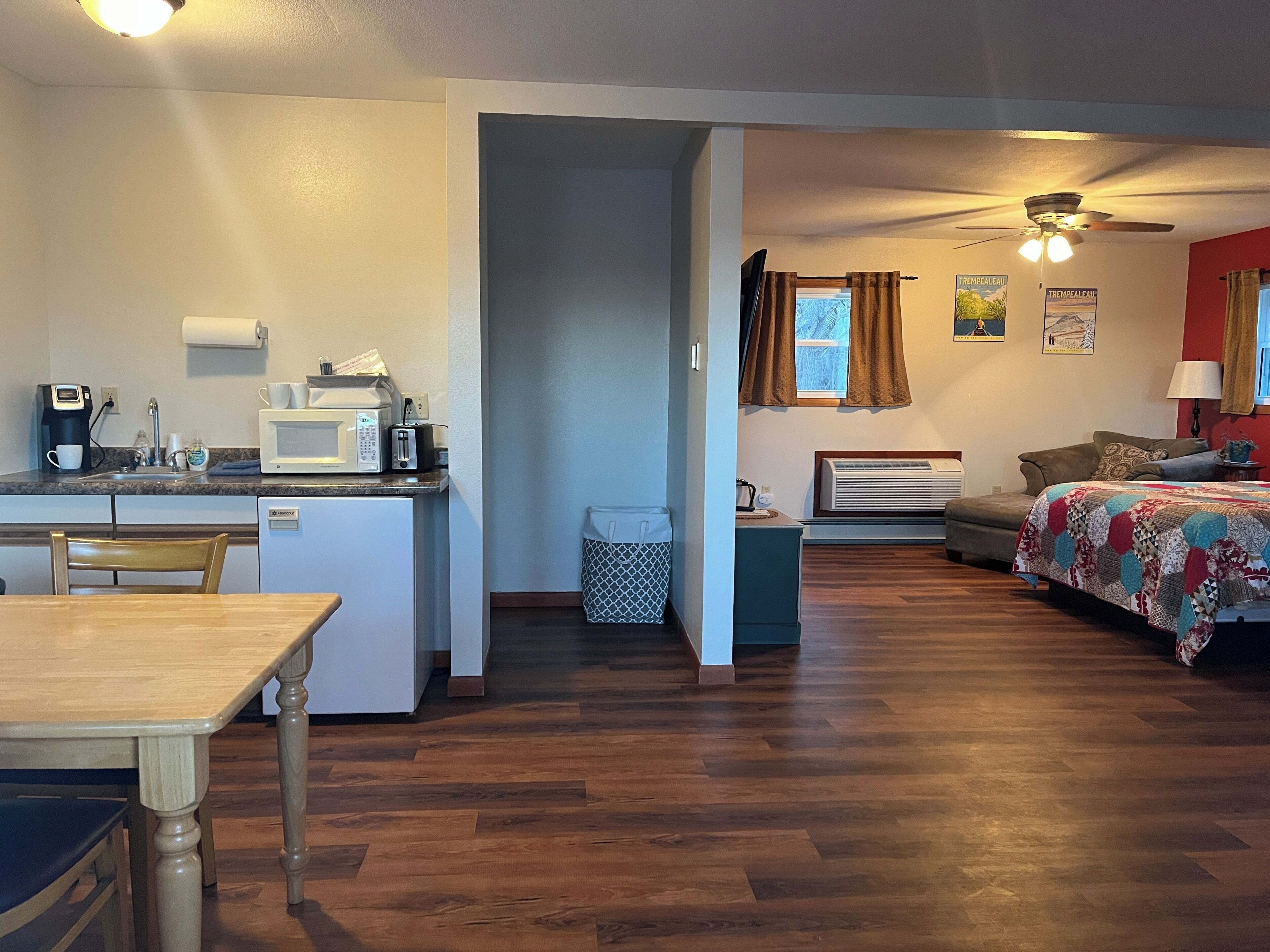 Un espacio habitable compacto con kitchenette, comedor y dormitorio.