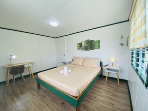 Relax in a stylish room with a large bed, desk, and artwork-adorned walls.