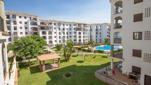 A multi-story hotel with a swimming pool, outdoor seating, and well-maintained gardens. - Lovely 2-Bed Apartment in Marina de la Duquesa (Puerto de la Duquesa)