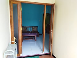 Una habitación con puerta de madera, un banco y una mesita.