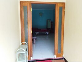 Una habitación con una cama, una mesita y una silla.
