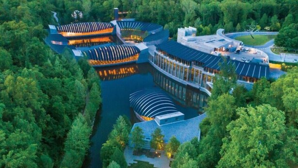Un hotel modern amb un disseny arquitectònic singular, caracteritzat per teulades corbes i una zona d'aigua central.