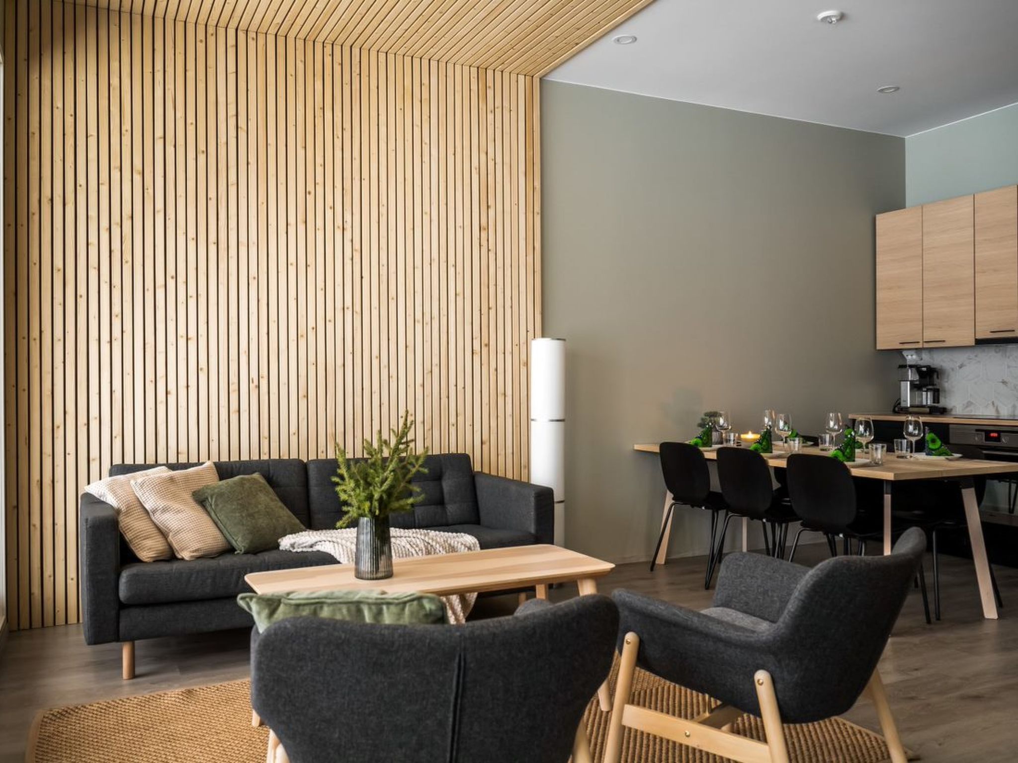 A modern living space with a sofa, a coffee table, and a dining area with chairs and a table.