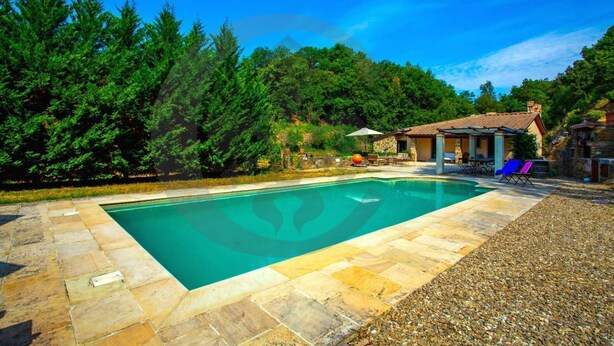 A rectangular swimming pool with stone tiles, surrounded by a stone deck. - Villa con Piscina, Sauna, Jacuzzi (Greve in Chianti)