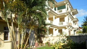 A multi-story residential building with balconies, surrounded by lush greenery and a well-maintained lawn. - Residence La Colombe Vacation Rentals (Mont Choisy)