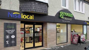 Fachada con letreros que dicen 'Nisa local' y 'greens de Markinch'.
