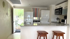 Una cocina moderna con una isla central, electrodomésticos integrados y vistas al exterior.