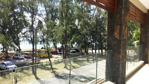 A balcony with a view of a parking area and trees. - West Front One No 4 With Seafront Beachfront Licensed By Tourism Authority 14977 (Flic-en-Flac)