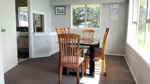 Comedor con una mesa, sillas y vistas al exterior.