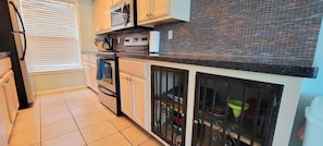 Enjoy cooking in this well-equipped kitchen with appliances, ample storage, and a convenient window.