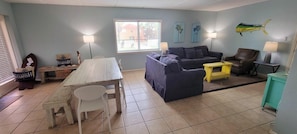 Relax in this inviting living room with a sofa, dining table, and comfortable chair.