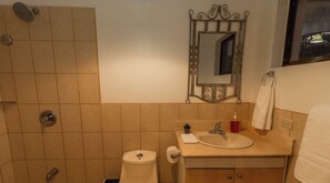 Een badkamer met toilet, wastafel en douche.