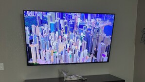 Un téléviseur à écran plat fixé sur un meuble de télévision en bois foncé, avec une cheminée en dessous.