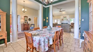 A spacious dining area with a table set for six, flanked by wooden chairs.