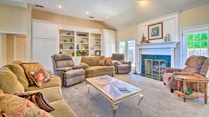 A spacious living room with a fireplace, built-in shelving, and comfortable seating.