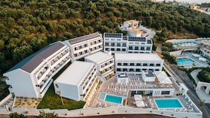 An aerial view of a modern hotel with multiple buildings, a swimming pool, and a landscaped area. - Tesoro Hotel Zakynthos (Zakynthos)