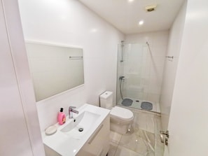 Ein modernes Badezimmer mit Waschbecken, Toilette und einer Dusche mit Glaswand.