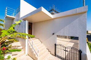 A modern house with a staircase, a gated entrance, and a clear blue sky. - Villa Alyssum (Miyakojima)