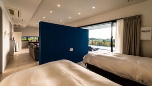 Una habitación de hotel moderna con dos camas, un ventanal con vistas al campo, un balcón y una sala de estar independiente con sofá y mesa.