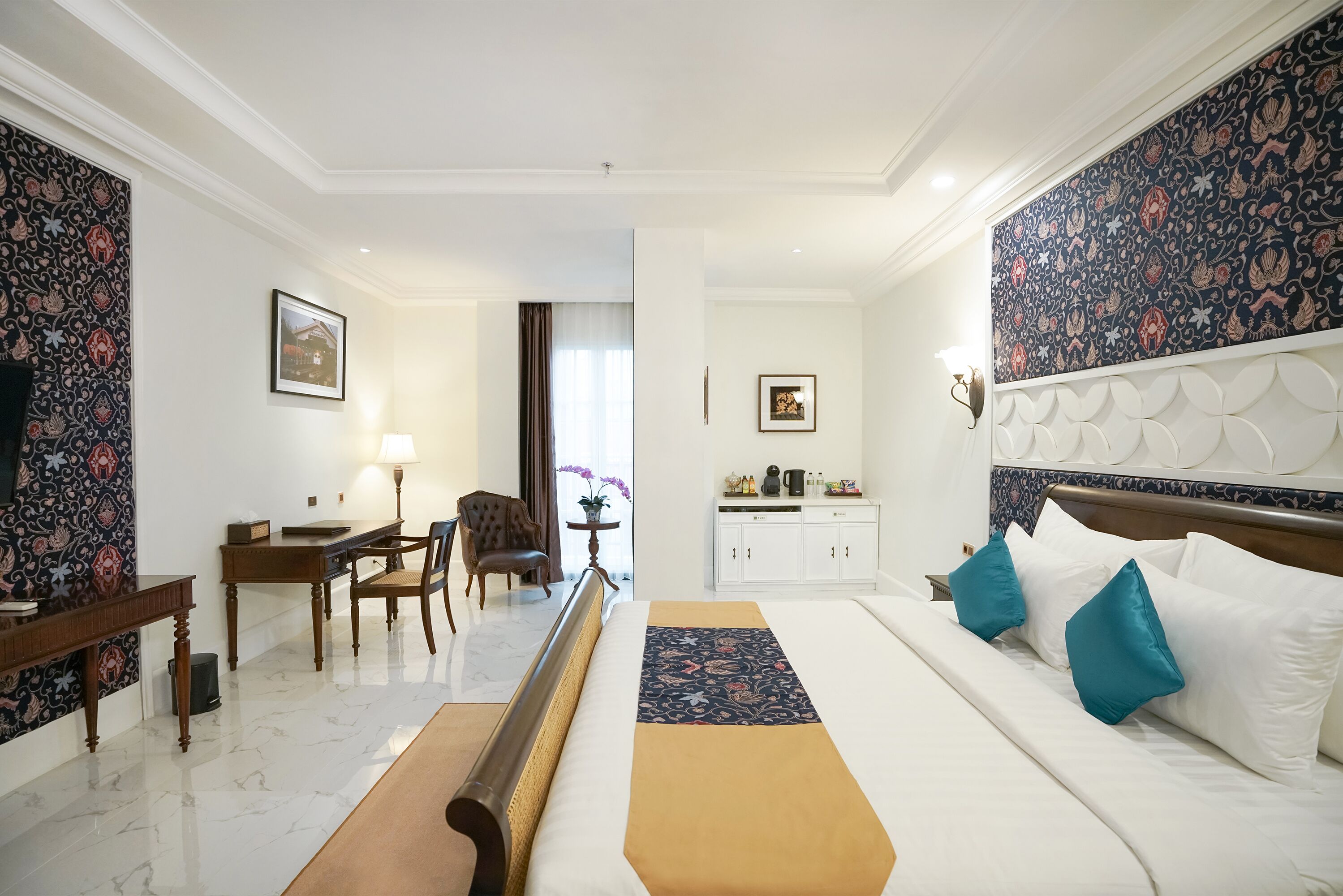 A hotel room with a bed, bedside table, lamp, and a view of the hallway.