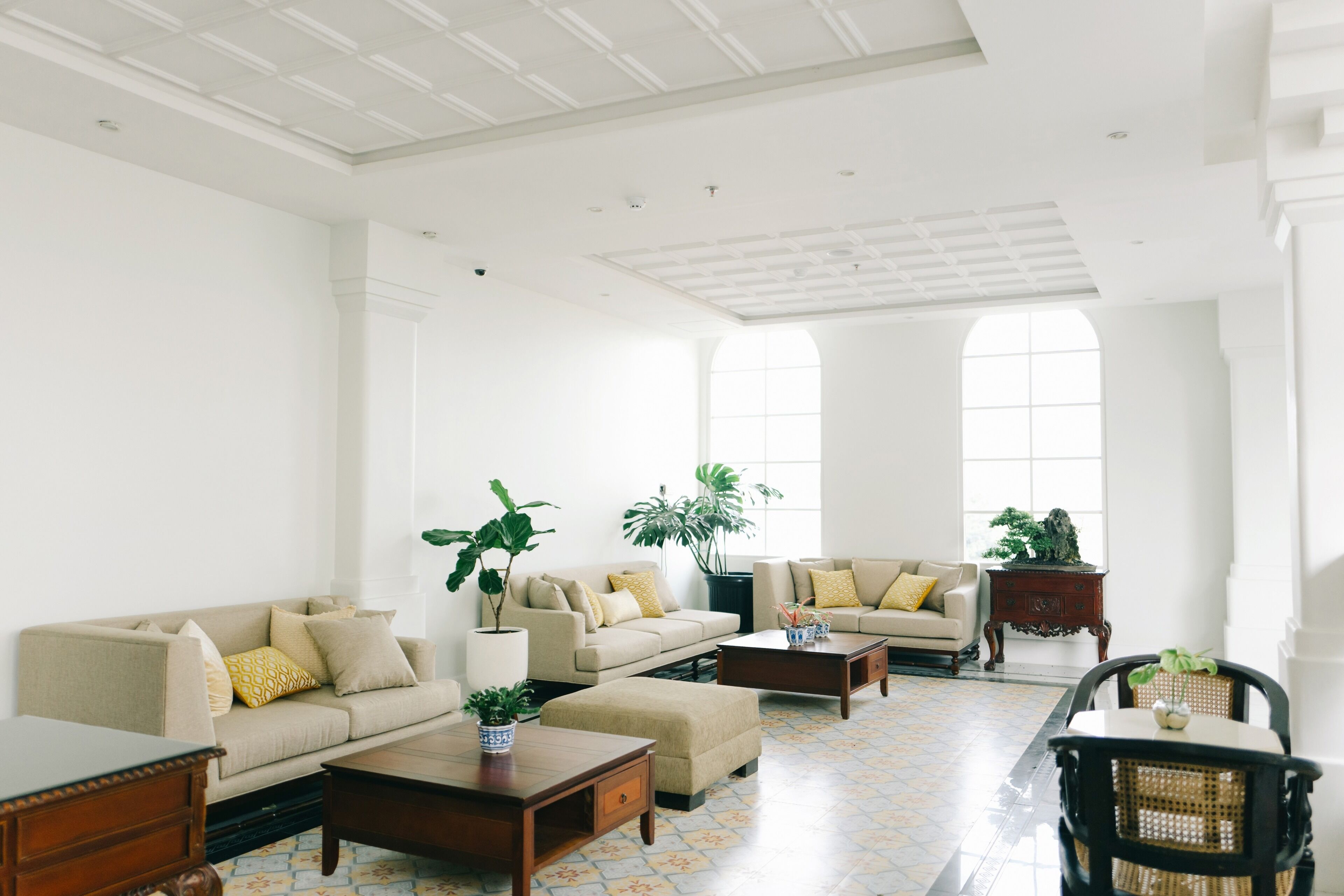 Un salón amplio con techo alto, ventanas grandes y una combinación de sofás y sillones.
