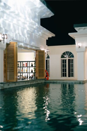Relax by the pool surrounded by a unique ceiling design and lush greenery.