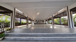 A spacious corridor with a polished floor, large windows, and a prominent wall with Chinese characters.