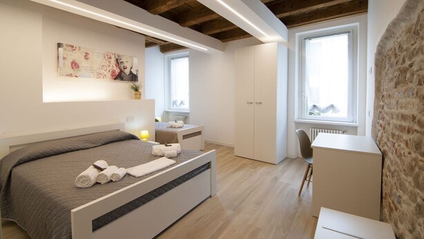 A modern bedroom with a bed, bedside table, and a desk.