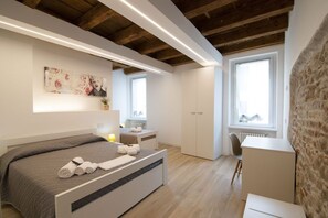 Un dormitorio moderno con cama, mesita de noche y escritorio.