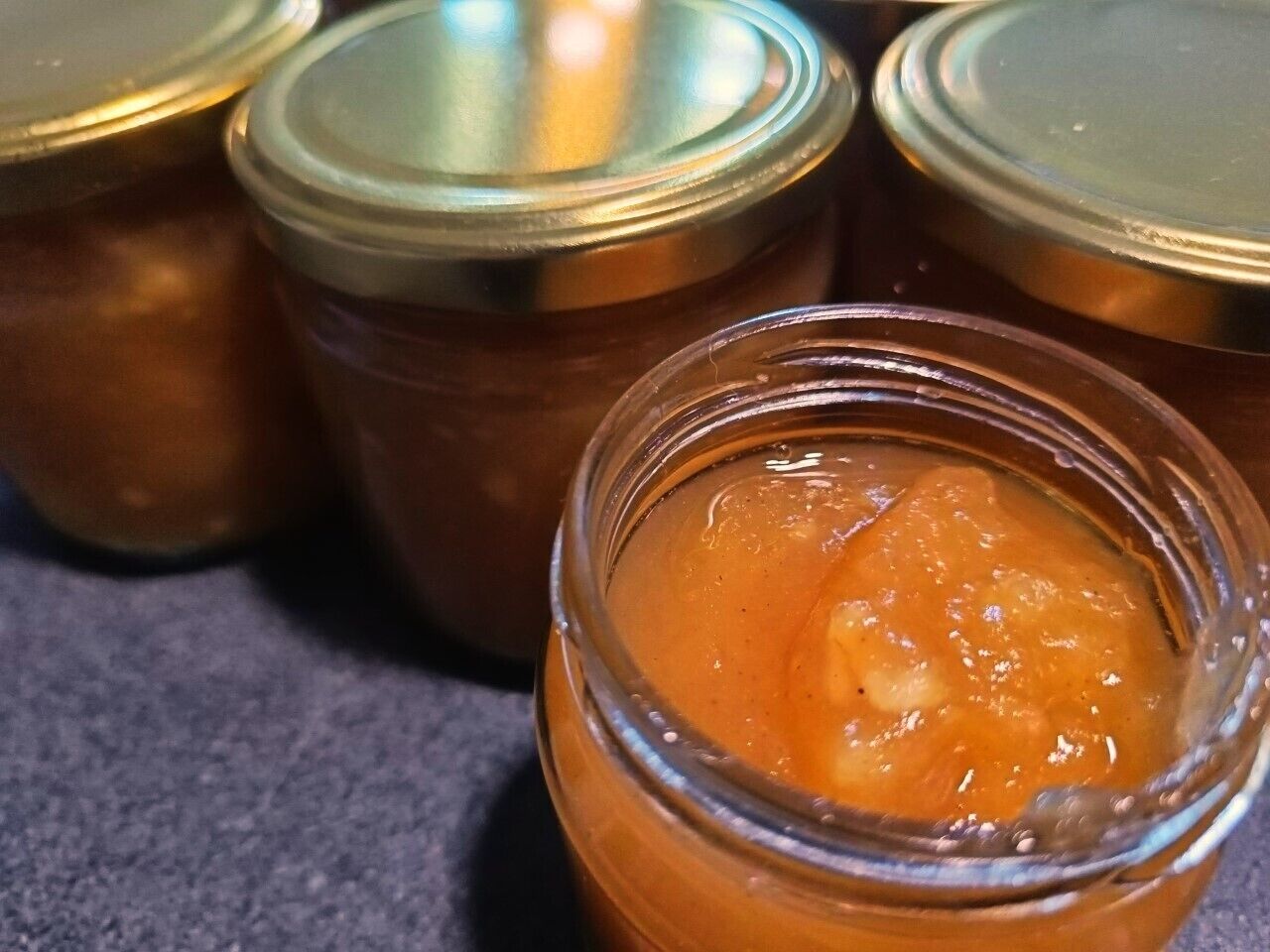 A jar of orange jam with a metal lid.